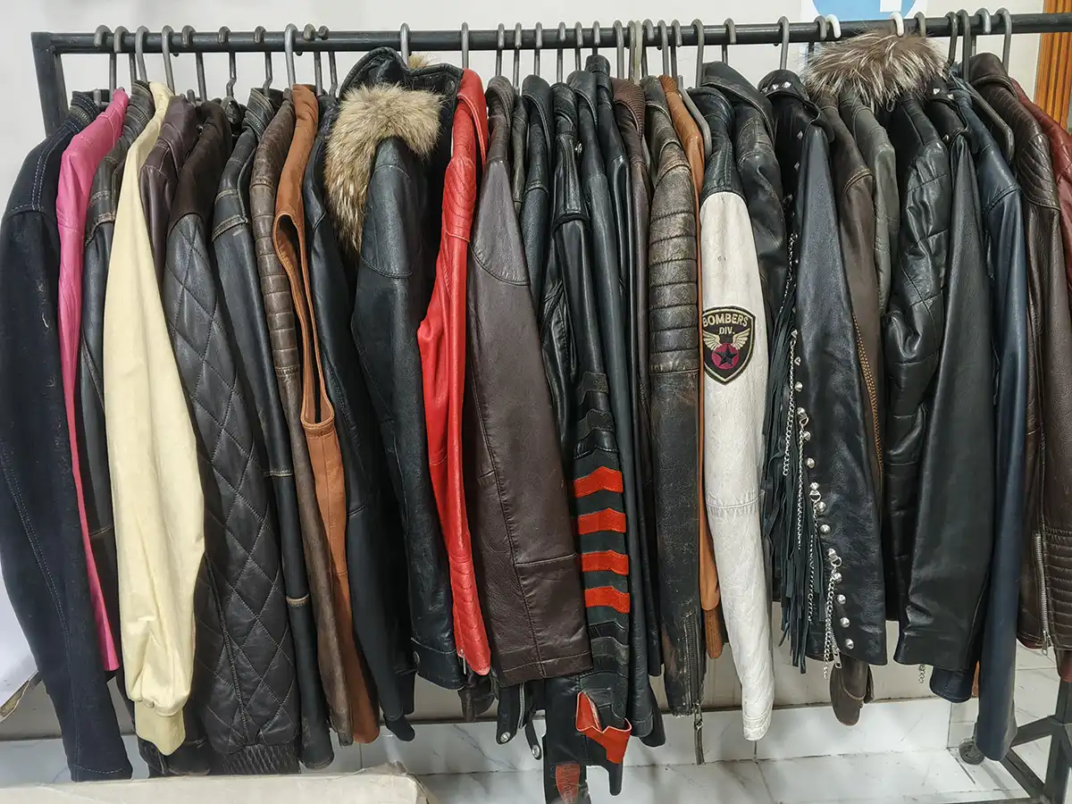 Leather jacket manufacturing process inside a professional factory with workers stitching jackets