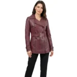 Woman wearing burgundy leather trench jacket with double breasted buttons belt and notch lapels on white background