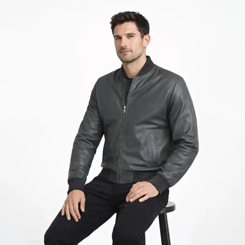 Seated view of gray leather bomber jacket showing smooth leather panels ribbed hem waistband and classic construction