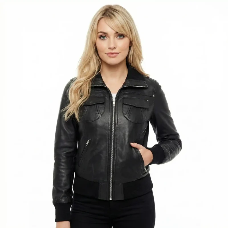 Astra Prime Leather Bomber Front View - Women's Black Leather Bomber Jacket Woman wearing Astra Prime black leather bomber jacket with shirt collar, center zip closure, dual chest flap pockets, ribbed knit cuffs and hem, and all-black outfit on white background