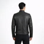 Rear view of black leather cafe racer jacket showing center back seam, shoulder panels, tapered waist construction, and straight hem detail