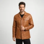 Man wearing tan cognac brown leather jacket with notch collar, button-front closure, dual chest flap pockets, lower patch pockets, and black shirt on light gray background - Aurelius Heritage Leather
