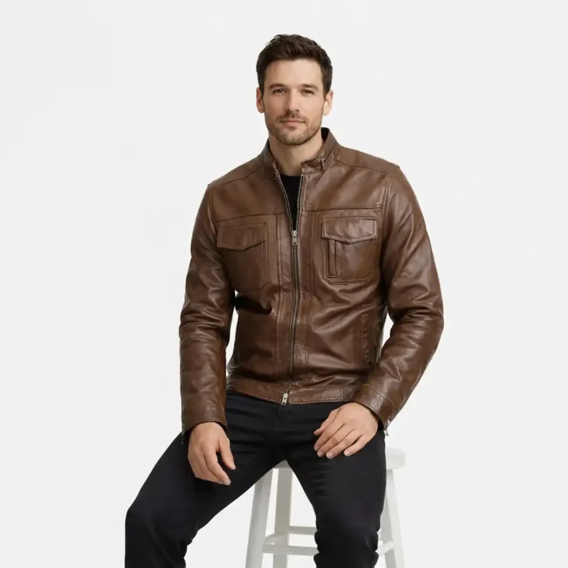 Man seated wearing brown leather aviator jacket showing comfortable range of motion, chest pocket accessibility, natural leather draping, and relaxed fit while sitting