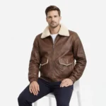 Man seated wearing brown leather aviator jacket showing comfortable fit, luxurious shearling collar, functional chest pockets, practical everyday wear