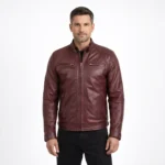 Front view of men's burgundy oxblood leather motorcycle jacket with stand collar, central zipper, horizontal chest zip pockets, diagonal waist pockets, and raglan sleeves