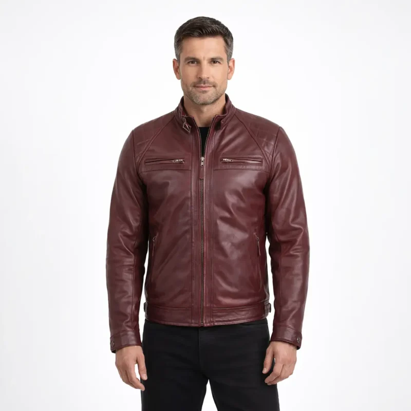 Front view of men's burgundy oxblood leather motorcycle jacket with stand collar, central zipper, horizontal chest zip pockets, diagonal waist pockets, and raglan sleeves