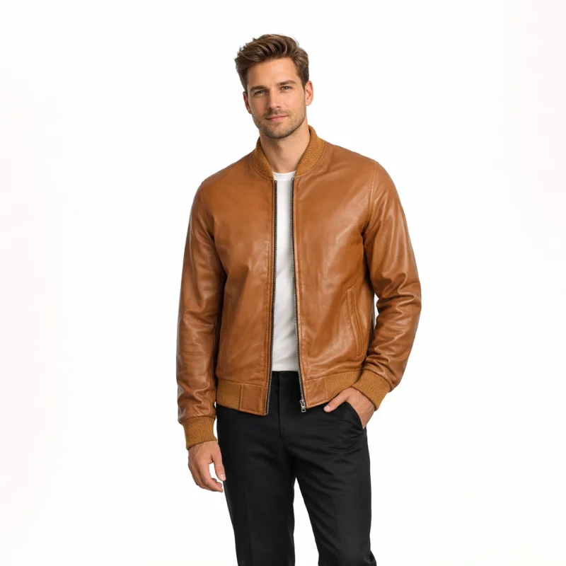 Front view of men's tan cognac leather bomber jacket with ribbed knit collar, central zipper, slash hand pockets, ribbed cuffs and hem, and smooth caramel brown leather finish in classic baseball jacket style
