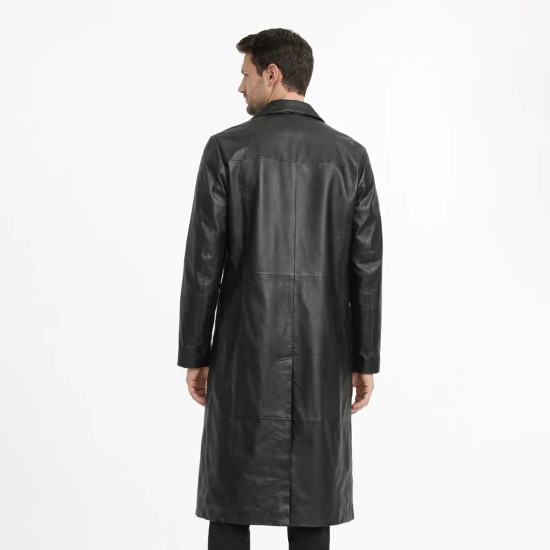 Rear view of black leather trench coat showing clean back panel, center vent, knee-length proportion, classic overcoat construction