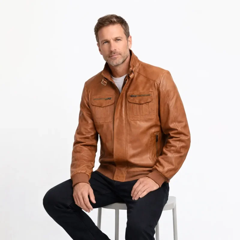 Tan Leather Bomber Jacket Seated Fit | Men's Brown Leather Jacket Comfort Man wearing tan brown leather bomber jacket while seated, demonstrating comfortable fit, buckle collar detail, and quality leather construction