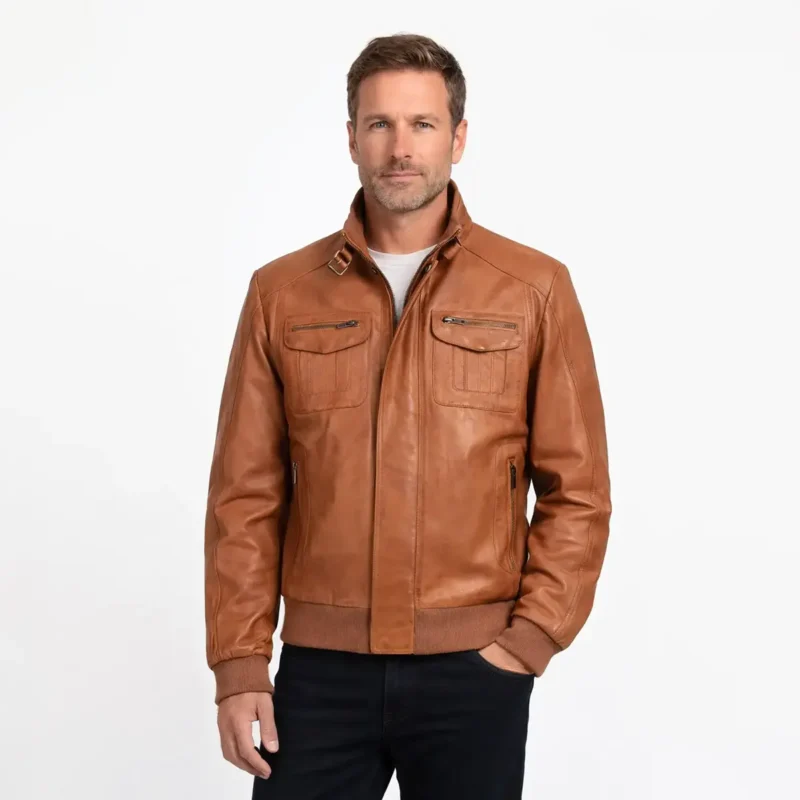 Men's tan brown leather bomber jacket with stand-up buckle collar, dual chest pockets with zippers, ribbed cuffs and waistband - front view