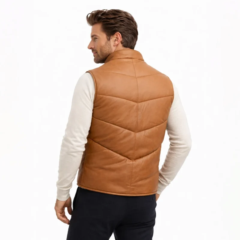 Man wearing tan leather puffer vest layered over cream long-sleeve shirt and navy pants for casual refined look of Cognac Puffer Leather Vest