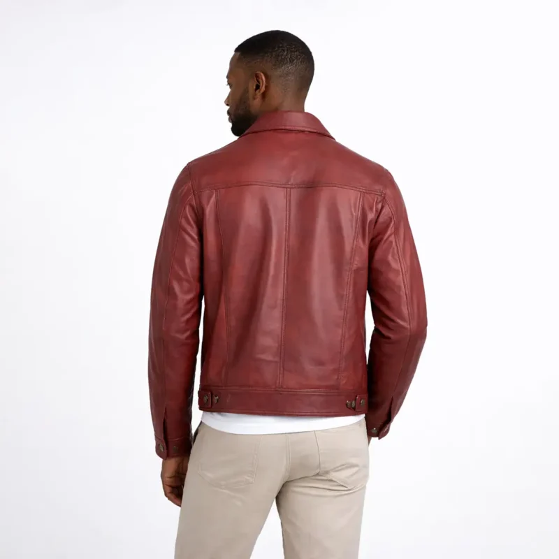 Rear view of burgundy leather trucker jacket showing yoke construction, center back seam, side panel seaming, straight hem, and rich red wine-colored leather finish