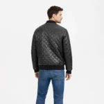 Rear view of black quilted leather bomber jacket showing continuous diamond quilting pattern across back and sleeves, ribbed knit hem, center back construction, and luxurious padded texture