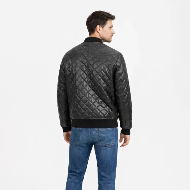 Rear view of black quilted leather bomber jacket showing continuous diamond quilting pattern across back and sleeves, ribbed knit hem, center back construction, and luxurious padded texture