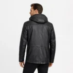 Rear view of black leather field jacket showing removable hood, clean back panel, relaxed fit, hip-length cut