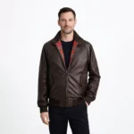 Front view of men's brown leather Harrington jacket with fold-down collar, red tartan plaid lining, central zipper, slash hand pockets, ribbed cuffs and hem