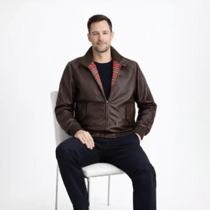 Man seated wearing brown leather Harrington jacket showing comfortable fit, visible red plaid lining, and practical everyday wearability