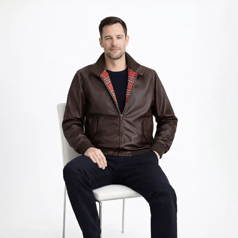 Men's Brown Leather Harrington Jacket Seated Position - Comfort and Style Man seated wearing brown leather Harrington jacket showing comfortable fit, visible red plaid lining, and practical everyday wearability