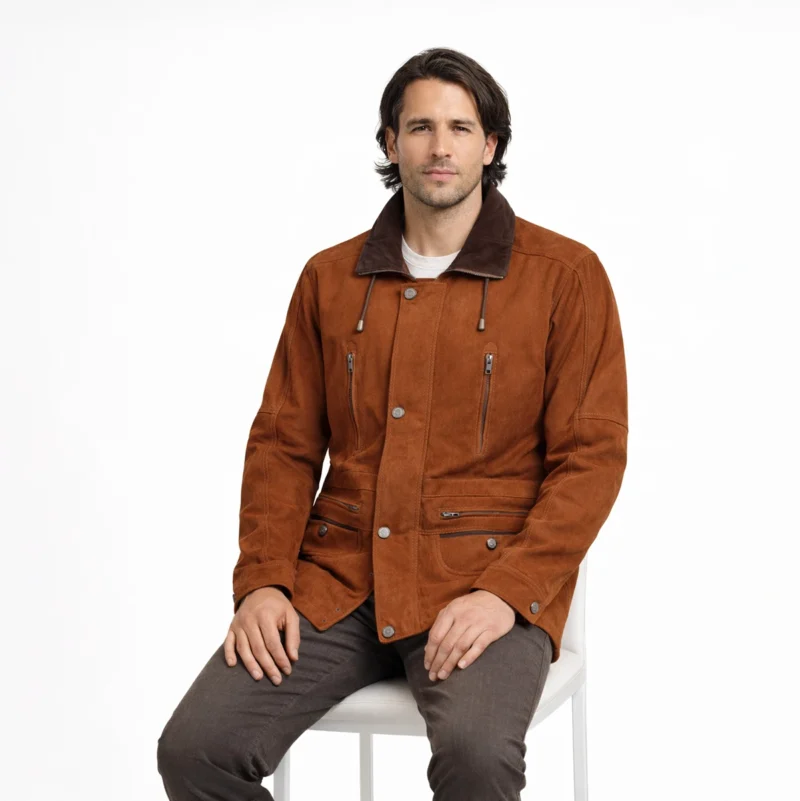 Man seated wearing tan suede field jacket with shearling collar showing comfortable fit, accessible pockets, luxurious materials