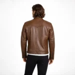 Rear view of brown distressed leather motorcycle jacket showing raglan sleeve construction, center back panel, horizontal waist seaming, straight hem, and vintage weathered finish