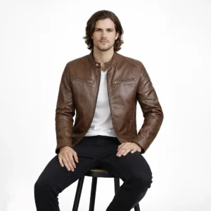Man seated wearing brown leather cafe racer jacket showing comfortable raglan sleeve movement, natural leather draping, chest pocket accessibility, and unrestricted fit while sitting