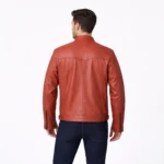 Rear view of terracotta orange leather cafe racer jacket showing center back seam, shoulder panels, horizontal waist seaming, straight hem with side adjusters, and vibrant burnt orange finish
