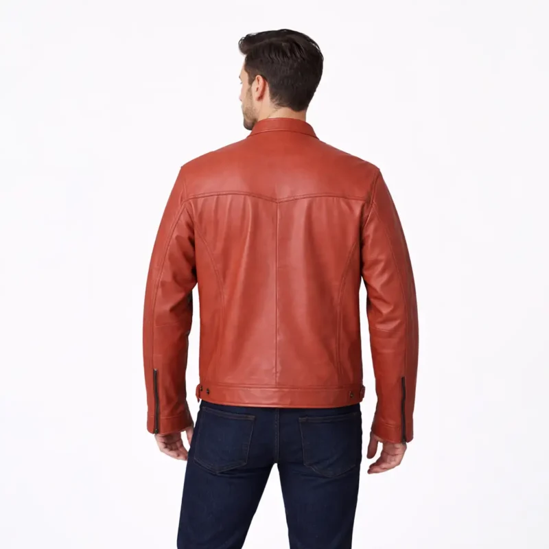 Rear view of terracotta orange leather cafe racer jacket showing center back seam, shoulder panels, horizontal waist seaming, straight hem with side adjusters, and vibrant burnt orange finish