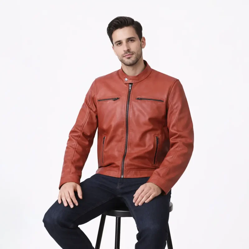 Man seated wearing terracotta orange leather cafe racer jacket showing comfortable fit, natural leather movement, pocket accessibility, and vibrant color in seated position