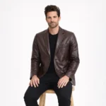 Man seated wearing brown leather blazer showing comfortable fit, accessible pockets, refined styling, smart-casual outerwear - Imperial Aurelius Leather Blazer
