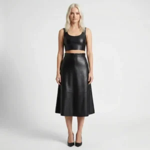 Front view of model wearing high-waisted black leather midi skirt with vertical panel seams and A-line silhouette against white background.