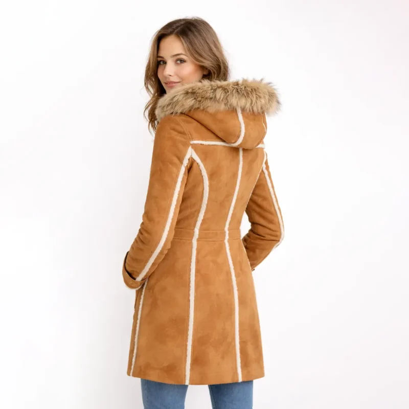 Back profile of tan shearling coat showing fitted waist, flared hem, fur-trimmed hood, and sherpa lining detail