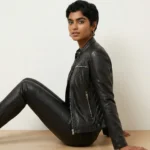 Side profile of black leather moto jacket showing asymmetric zipper, quilted shoulder, fitted feminine silhouette, multi-pocket layout of Midnight Luxe Zip-Front Leather Jacket