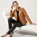 Women's tan cognac leather moto jacket with wide notched lapels, asymmetric zipper closure, diagonal zipper pockets, and classic biker styling - front view of Noir Prestige Slim-Fit Leather Jacket