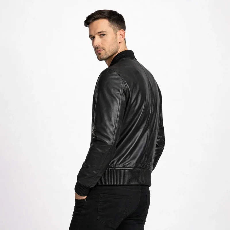 Side profile of black leather bomber jacket showing ribbed trim, streamlined silhouette, contemporary relaxed fit, and premium leather quality
