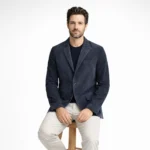Man wearing navy blue suede blazer while seated, demonstrating tailored fit and luxurious suede texture - Noir Valence Suede Blazer