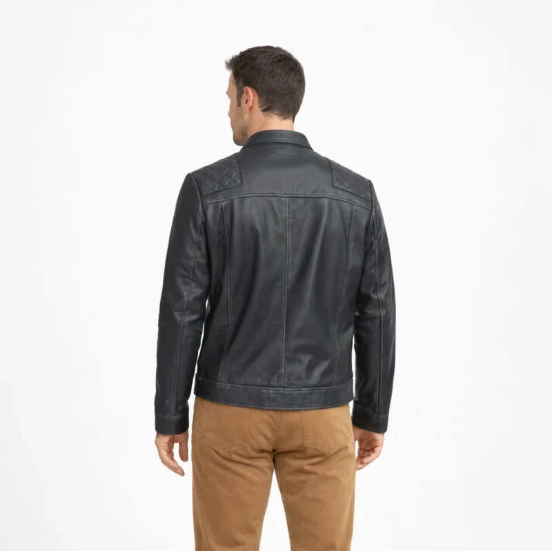 Rear view of black leather racer jacket displaying diamond quilted shoulder yoke, smooth back panel, and fitted waist hem