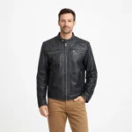 Man wearing black leather racer jacket with diamond quilted collar and shoulders, center zip closure, chest zip pockets, and tan chinos on light gray background