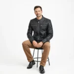 Man seated wearing black leather racer jacket with tan chinos, demonstrating comfort, mobility, and shape retention while sitting