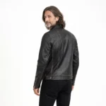 Rear view of distressed black leather biker jacket showing smooth back panel, brass zipper accents on sleeves, and vintage finish with brown undertones