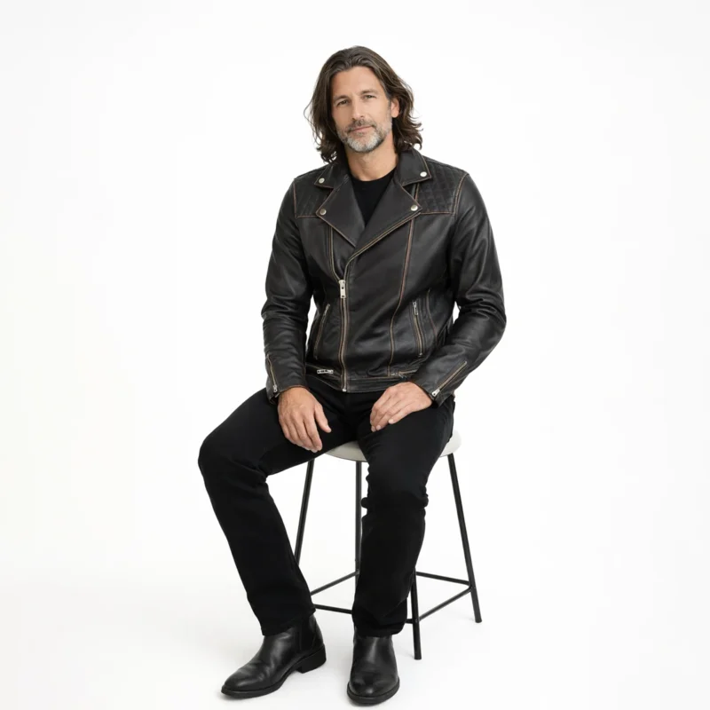 Black Leather Biker Jacket Seated Position - Men's Comfortable Vintage Moto Jacket Man seated wearing distressed black leather biker jacket with all black outfit, demonstrating comfort, flexibility, and maintained structure while sitting