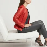 Side profile of red leather bomber jacket showing V-neck, fitted silhouette, ribbed trim details, and cropped length
