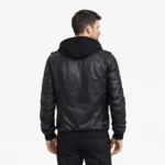 Rear view of black leather bomber jacket showing removable hood, clean back panel, shoulder straps, ribbed hem, distressed finish