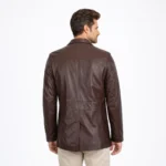 Back view of brown leather blazer coat showing center back seam vertical panels and structured shoulders