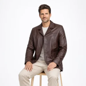 Seated profile of man in brown leather blazer coat showing hip length cut structured fit and notch collar