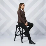 Woman seated wearing brown leather moto jacket - Rustic Charm Leather Rider Jacket - showing comfortable fitted cut, belted waist, accessible pocket, versatile styling