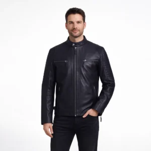 Man wearing black leather motorcycle jacket with stand collar, center zip closure, ribbed shoulder panels, horizontal chest zip pockets, and black jeans on light gray background