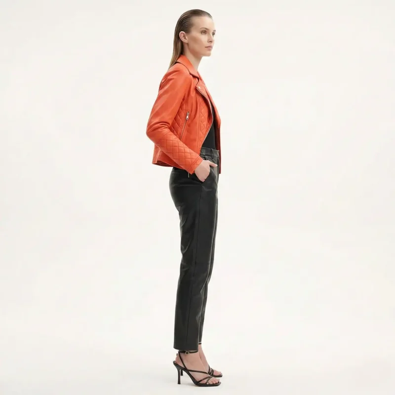 Side profile of woman in orange quilted leather biker jacket - Urban Dynasty Leather Jacket - showing diamond pattern stitching and fitted silhouette