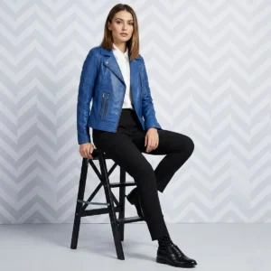 Woman wearing royal blue leather moto jacket with asymmetric zipper and wide lapels sitting on black stool - Velour Rebel Leather Jacket