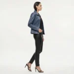 Side profile view of woman in blue leather moto jacket showing fitted silhouette hip length and asymmetric zipper