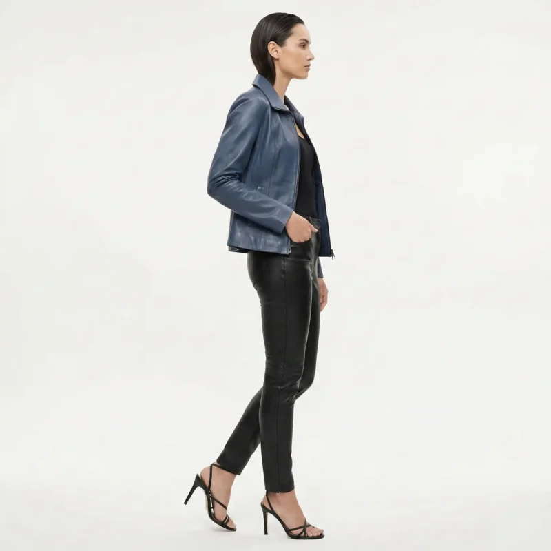 Side profile view of woman in blue leather moto jacket showing fitted silhouette hip length and asymmetric zipper